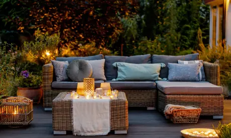 Útulná podzimní terasa s gaučem a stolečkem.